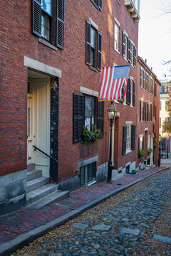 Acorn Street Beacon Hill House During Fall Harvest With American Flag And Cobblestone Alley In Boston, Massachusetts.