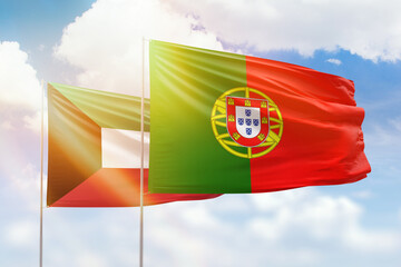 Sunny blue sky and flags of portugal and kuwait