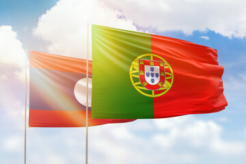 Sunny blue sky and flags of portugal and laos