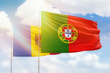 Sunny blue sky and flags of portugal and moldova