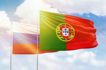 Sunny blue sky and flags of portugal and russia