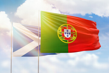 Sunny blue sky and flags of portugal and scotland