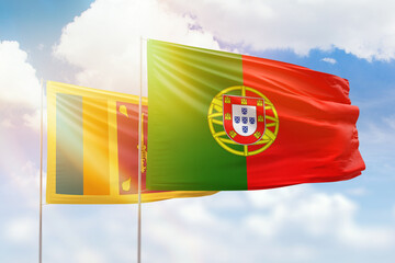 Sunny blue sky and flags of portugal and sri lanka
