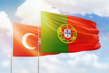 Sunny blue sky and flags of portugal and turkey