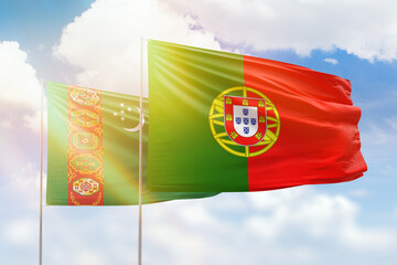 Sunny blue sky and flags of portugal and turkmenistan