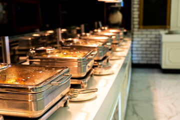 Many buffet heated trays ready for service in hotel restaurant