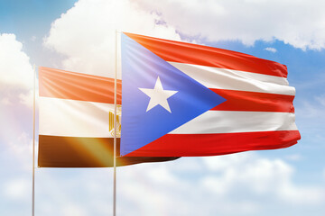 Sunny blue sky and flags of puerto rico and egypt