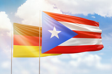 Sunny blue sky and flags of puerto rico and germany