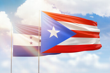 Sunny blue sky and flags of puerto rico and honduras