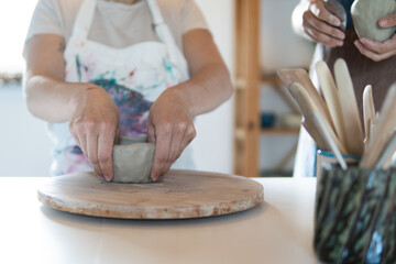 Fototapeta na wymiar A female hands works with clay making the future ceramic bowl.