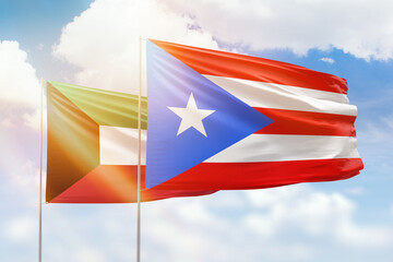 Sunny blue sky and flags of puerto rico and kuwait