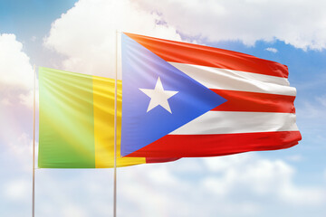Sunny blue sky and flags of puerto rico and mali