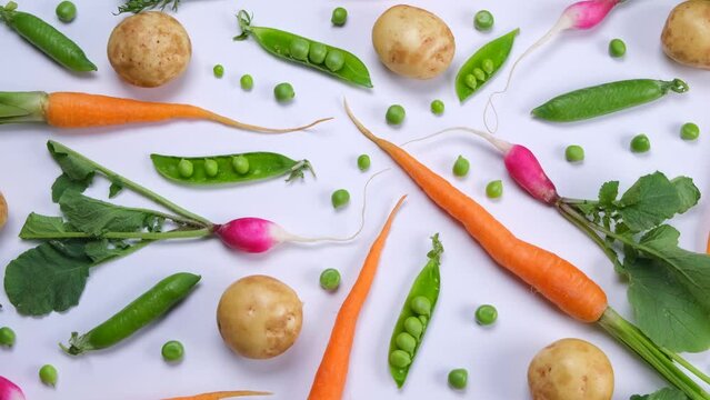 Vegetable rotating background of potatoes, peas, carrots and radishes, fashionable vegetable texture on a bluish background