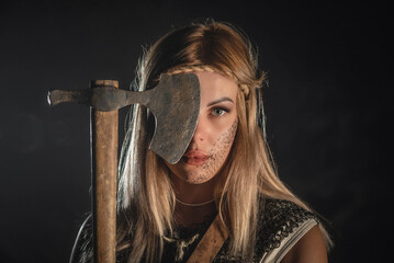 Beautiful woman warrior with the axe concept.