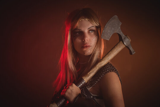 Beautiful woman warrior with the axe concept.