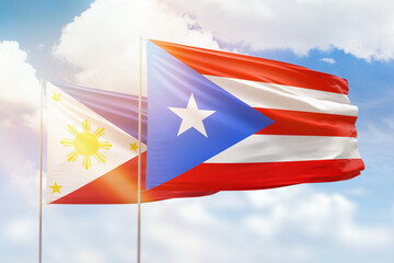 Sunny blue sky and flags of puerto rico and philippines