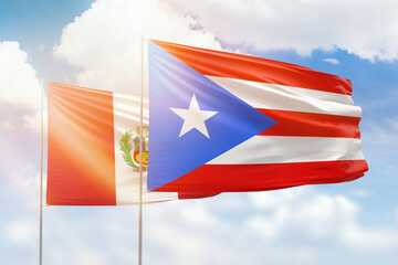 Sunny blue sky and flags of puerto rico and peru