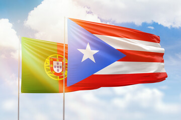 Sunny blue sky and flags of puerto rico and portugal