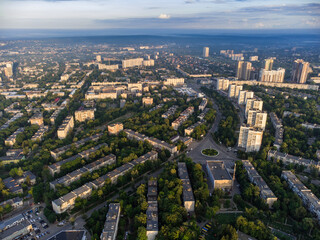 Fototapeta na wymiar Sunny morning city view in summer green city, residential district. Aerial cityscape above buildings and streets, Pavlovo Pole, Kharkiv Ukraine