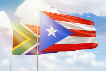 Sunny blue sky and flags of puerto rico and south africa
