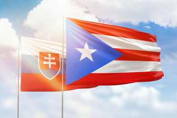 Sunny blue sky and flags of puerto rico and slovakia