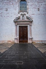 Fototapeta premium Detail of an ancient palace facade in the village of Spello (Umbria Region, Central Italy), a medieval village, famous for a flower country fair, named Infiorata (held yearly, between May and June).