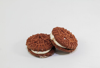 Chocolate biscuits covered with sugar cream, photo on a white background