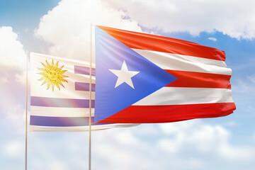 Sunny blue sky and flags of puerto rico and uruguay