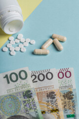 Polish zloty zloty money, next to scattered pills and medications