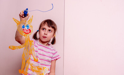 Beautiful young girl painting with fingers on the glass  red cat and blue sky. Copy space.