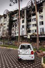 Shot cars. On the streets of Irpin. Cities of Ukraine after the Russian occupation. Irpin, Bucha, Hostomel. Destroyed and burnt houses in the background.