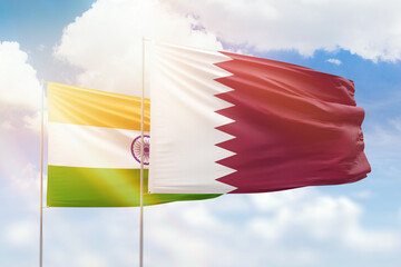 Sunny blue sky and flags of qatar and india