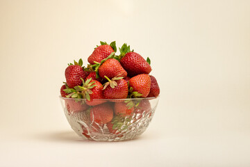 strawberries in a glass bowl. strawberries in a glass bowl on a cocoa background