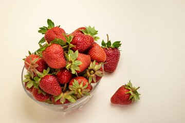 strawberries in a glass bowl. strawberries in a glass bowl on a cocoa background