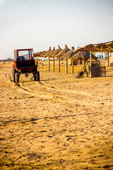 a tractor cleaning sand on the morning beach