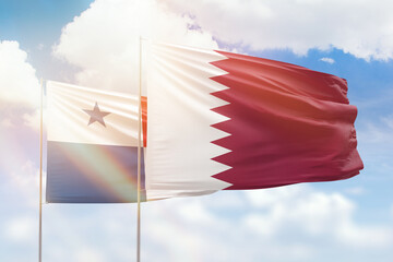 Sunny blue sky and flags of qatar and panama