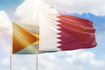 Sunny blue sky and flags of qatar and bahamas