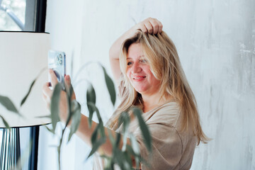 People technology and candid mood portrait - happy smiling  plus size woman taking selfie at home