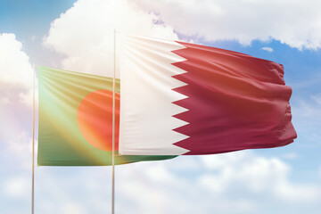 Sunny blue sky and flags of qatar and bangladesh