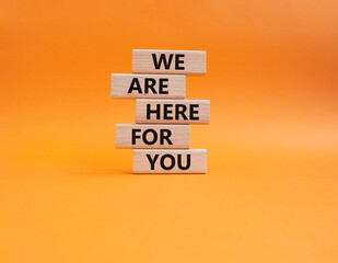 Help symbol. Wooden blocks with words 'We are here for you'. Beautiful orange background. Business and 'We are here for you' concept. Copy space.