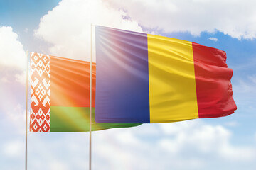 Sunny blue sky and flags of romania and belarus