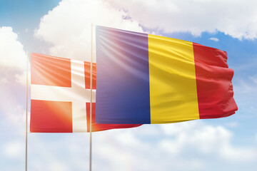 Sunny blue sky and flags of romania and denmark