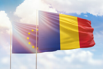 Sunny blue sky and flags of romania and european union