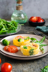 Portioned omelet from eggs, broccoli and tomatoes on a plate. Homemade breakfast. Vertical view