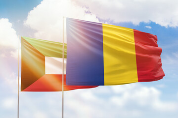 Sunny blue sky and flags of romania and kuwait