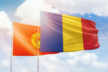 Sunny blue sky and flags of romania and kyrgyzstan