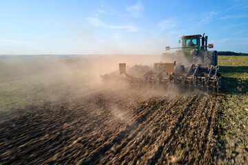 Aerial view of tractor plowing agriculural farm field preparing soil for seeding in summer - obrazy, fototapety, plakaty