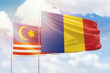 Sunny blue sky and flags of romania and malaysia