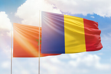 Sunny blue sky and flags of romania and morocco
