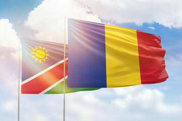 Sunny blue sky and flags of romania and namibia